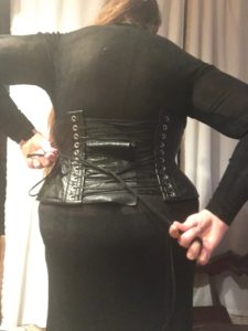 Miss R tightening the laces on the black corset over the black dress
